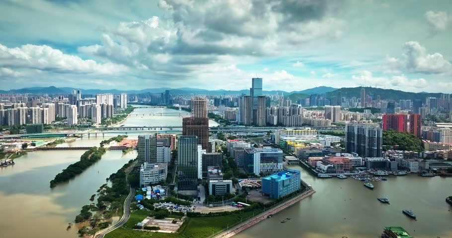 Aerial shot of a modern metropolis with rivers, bridges, and a dramatic skyline in Zhuhai.