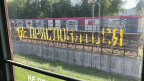 View From A Moving Commuter Train Through A Window With A "Do Not Lean" Warning Sign In Russian. Passing Scenery Blurred By Motion. - Powered by Shutterstock - Get 15% off with code: PIKWIZARD15