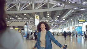 Attractive Latino woman hugging her friend in the airport terminal. Beautiful young female tourist traveler feel happy and emotional while reunites with friend after arriving for holiday vacation trip - Powered by Shutterstock - Get 15% off with code: PIKWIZARD15