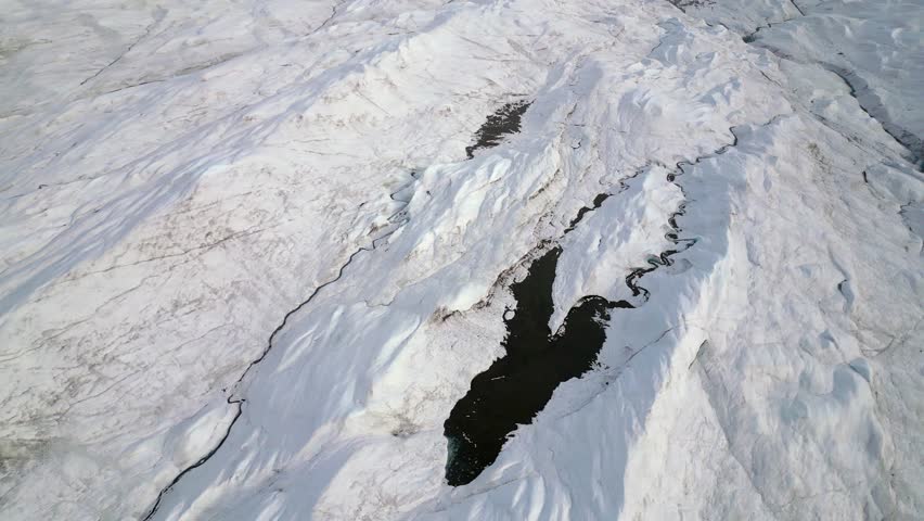 Flowing water carves channels in ice of arctic glacier in Greenland