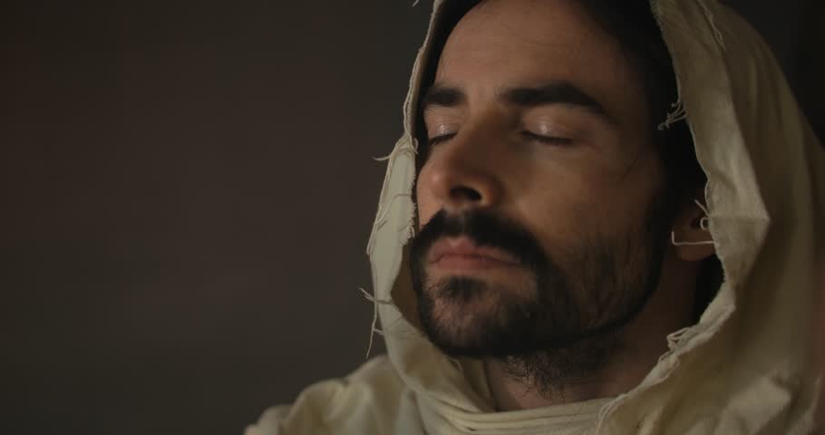 Jesus Christ in ambient light holding bread for communion, Passover, last supper for Christianity stock footage.