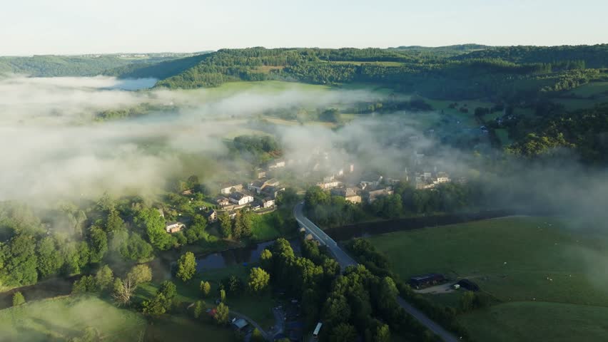 Morning fog over Dohan village and green Ardennes landscape, aerial