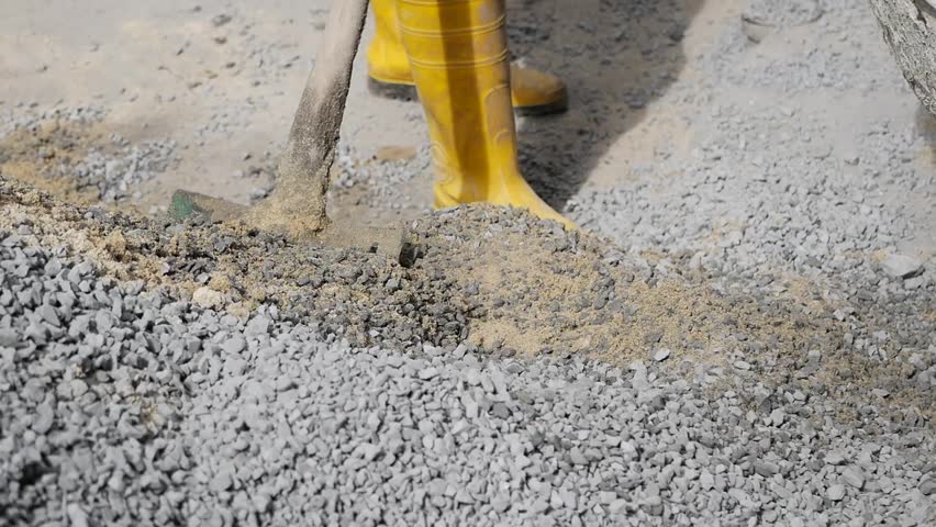 Worker preparing gravel for construction in urban area