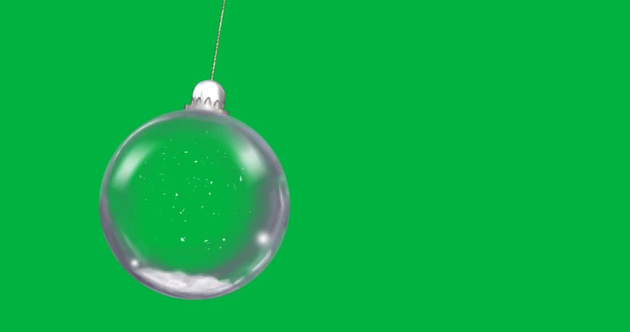 Designers using glass bauble hanging on gold cord over transparent backdrop with snow for marketing. Ornament, elegance, minimalism, holiday, festive, luxury, winter