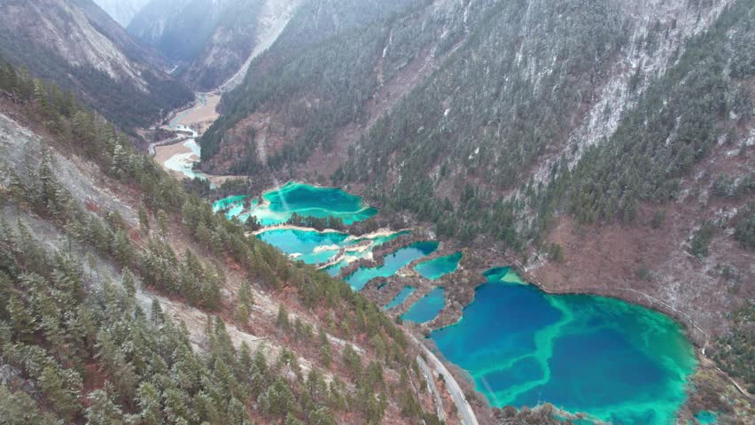 Drone view of Jiuzhaigou National Park in spring in Sichuan Province China. It features cascading waterfalls, turquoise blue lakes, and stunning mountain valleys. 4K real time footage travel concept.
