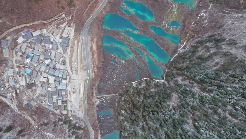 Drone view of Jiuzhaigou National Park in spring in Sichuan Province China. It features cascading waterfalls, turquoise blue lakes, and stunning mountain valleys. 4K real time footage travel concept.