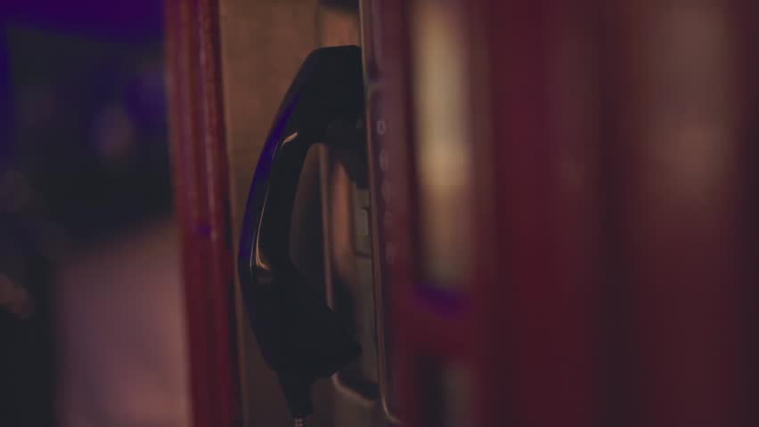 Old city phone booth at night, illuminated with warm light, capturing nostalgic urban atmosphere and cinematic nighttime streets.