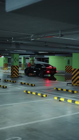 Black electric car driving in underground parking