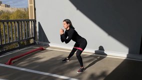 Trainer coach athlete sport woman in urban city young slim confident girl doing side lunges exercising wellness healthy lifestyle hips booty legs exercise fitness fit workout with rubber band on knees - Powered by Shutterstock - Get 15% off with code: PIKWIZARD15