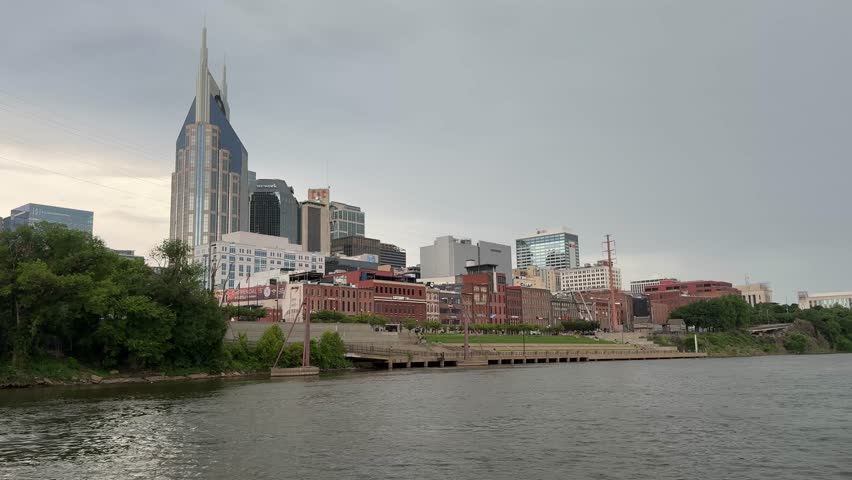 Nashville, Tennessee downtown city riverfront and skyline as seen from a boat along the Cumberland River on an overcast day