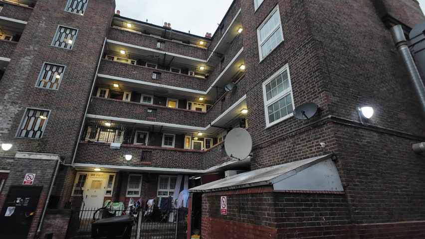 A pan clip of a government social housing estate in London of a dated construction during a grey Autumn late afternoon.