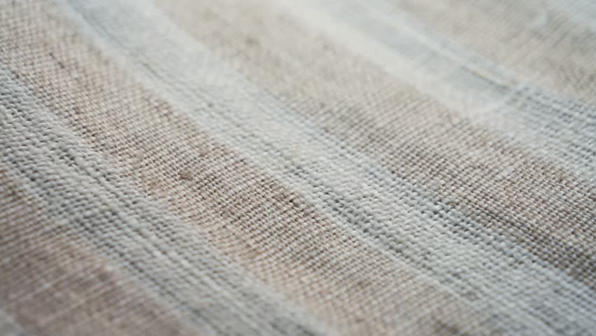 Textured beige fabric close up. Background and texture. High quality 4k footage