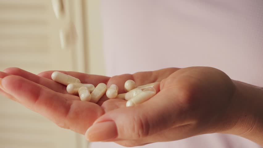 Pills in the hands of a woman. Tablet treatment. Vitamins, dietary supplements, pain relievers, and antipyretics. High quality 4k footage