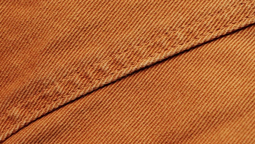 Brown denim fabric, seam on jeans close-up. High quality 4k footage