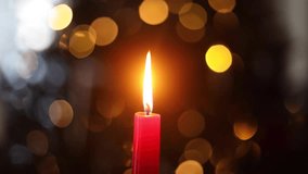 Burning christmas red candle on background of christmas tree with golden lights bokeh. Merry Christmas and Happy Holidays! Christmas advent, holiday candlelight background video - Powered by Shutterstock - Get 15% off with code: PIKWIZARD15
