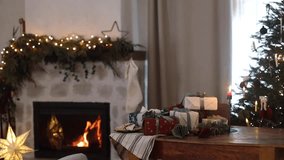 Stylish christmas presents, candle and gingerbread cookies on rustic table on background of festive decorated fireplace with lights and christmas tree. Holiday magical eve video. Merry Christmas! - Powered by Shutterstock - Get 15% off with code: PIKWIZARD15