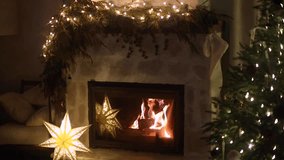 Burning festive decorated fireplace and christmas tree with twinkling lights in living room at night. Merry Christmas and Happy Holidays! Christmas cozy magical eve, holiday video - Powered by Shutterstock - Get 15% off with code: PIKWIZARD15
