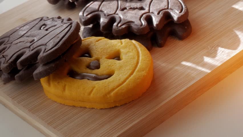 Colorful Halloween cookies on wooden board with playful designs