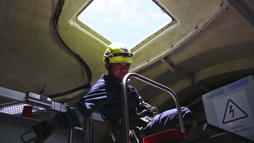 Two workers exiting wind turbine nacelle for maintenance tasks