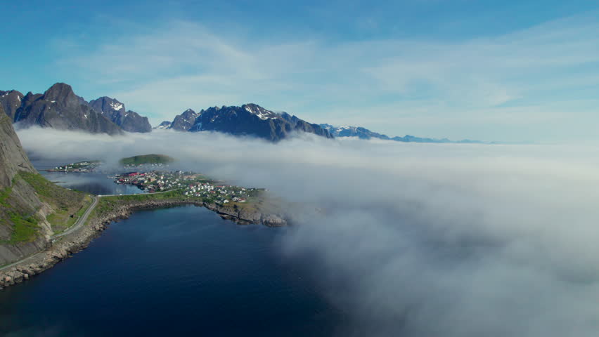 Stunning aerial view of the fishing village of Reine in Norway surrounded by mountains and sea fog