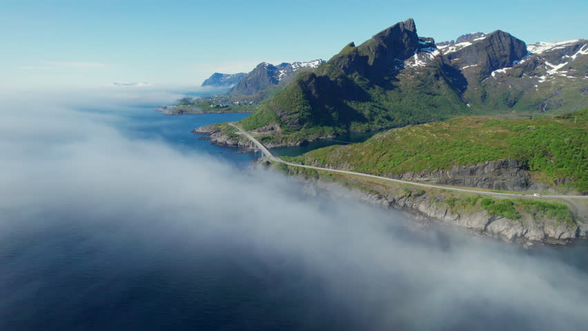 Stunning aerial footage of the picturesque village of Reine in Norway surrounded by low clouds