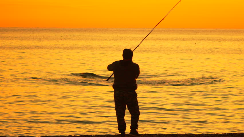 Fisherman fishing sunset, man casts rod into calm ocean during golden hour