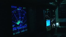 Flight deck instruments glowing in the dark as a pilot operates the complex avionics system. The radar display shows weather patterns ahead - Powered by Shutterstock - Get 15% off with code: PIKWIZARD15