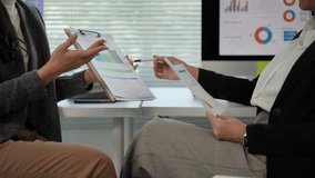 Businesswomen analyze financial data, pointing at charts and documents during an office meeting - Powered by Shutterstock - Get 15% off with code: PIKWIZARD15