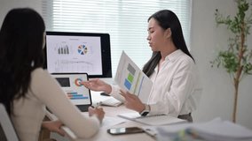 Businesswomen analyze financial reports, pointing at charts on computer screen and paper documents - Powered by Shutterstock - Get 15% off with code: PIKWIZARD15