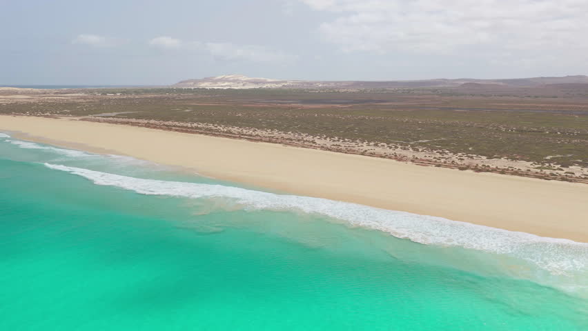 Aerial footage of Santa Monica Beach,showcasing endless white sand, turquoise waves, and a pristine,summer concept,Boa Vista, Cape Verde.