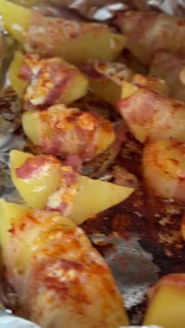 Step-by-step cooking video showing how to make baked potatoes wrapped in crispy bacon, seasoned with aromatic spices and coated in creamy mayonnaise. Delicious homemade recipe shot in close-up, showin