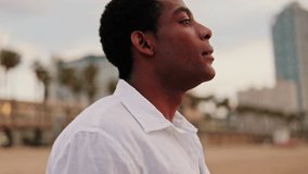 Young man breathes and reflects on Barceloneta Beach in Barcelona, Spain. He takes a deep breath and contemplates. - Powered by Shutterstock - Get 15% off with code: PIKWIZARD15