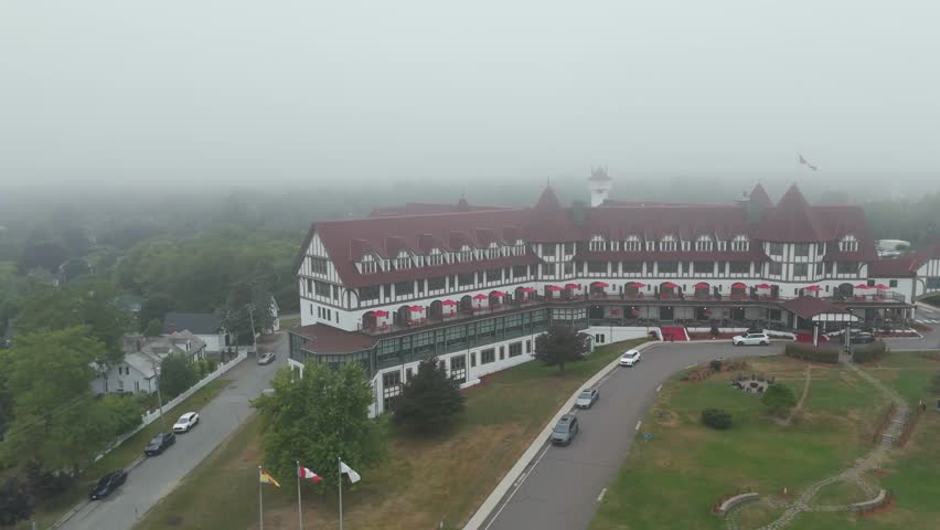 An aerial footage if a historic resort covered with mist in St. Andrews town, in Charlotte County, New Brunswick, Canada at sunset