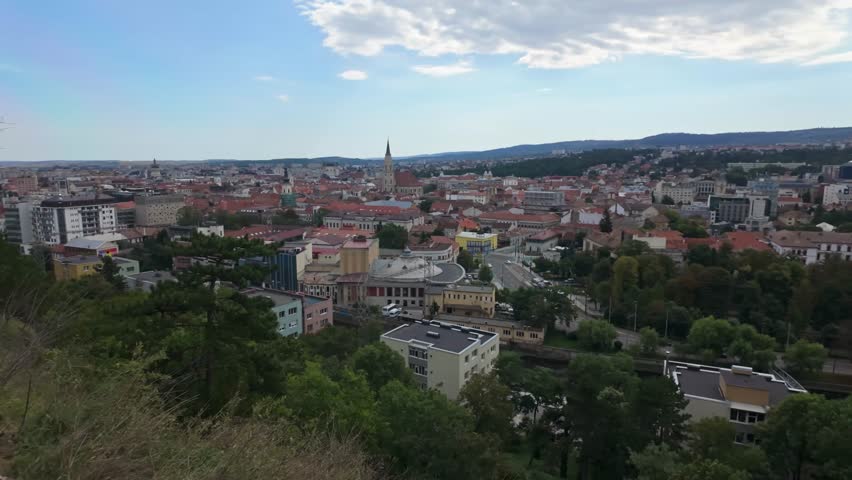 Panoramic view from Cluj Napoca city center and surroundings from the Cetățuia Park viewpoint on a sunny day in Romania.