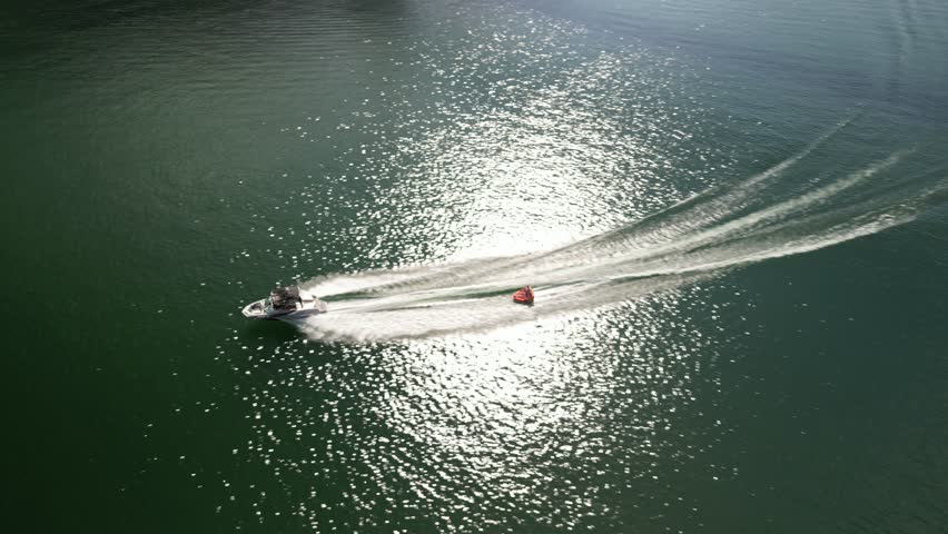 Aerial of boat pulling tube on lake Oroville in north California in summer