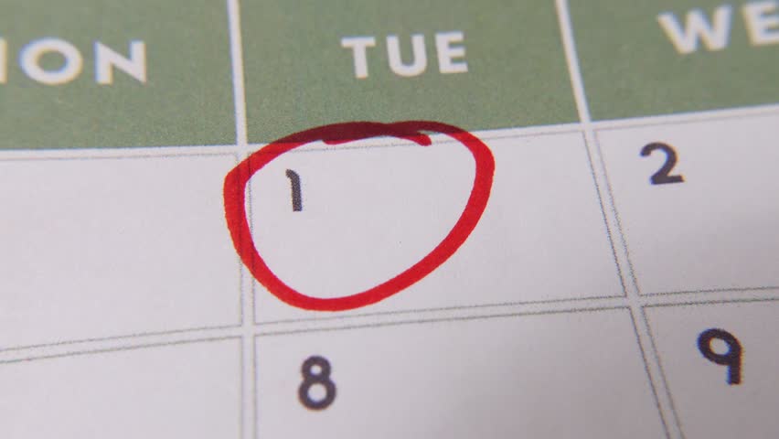 The 1st date on a calendar is circled with a red marker in a close-up macro shot on a white page, symbolizing an important day or reminder.