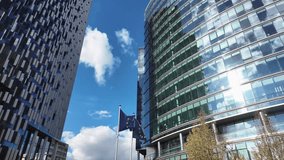 European Union flag fluttering between modern office towers near Maalbeek in Brussels, with the Lex building visible in the EU district. - Powered by Shutterstock - Get 15% off with code: PIKWIZARD15