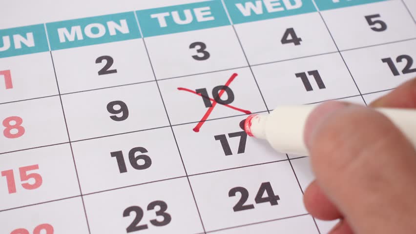 A monthly desk calendar with red crossed dates marked for scheduling, planning, and deadline reminders. Perfect for illustrating time management, productivity, and business organization concepts