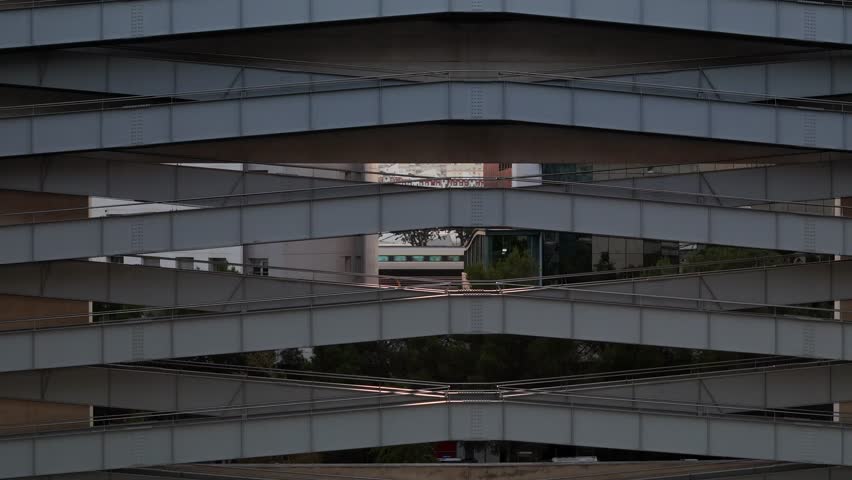 Modern architecture showcases unique design features in urban setting at sunset in Parque das Nacoes, Lisbon, Portugal as a train passes