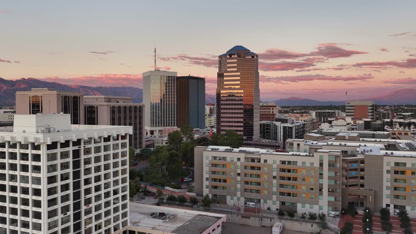 Ascending drone shot of downtown Tucson, Arizona at sunset with Catalina Mountains in background