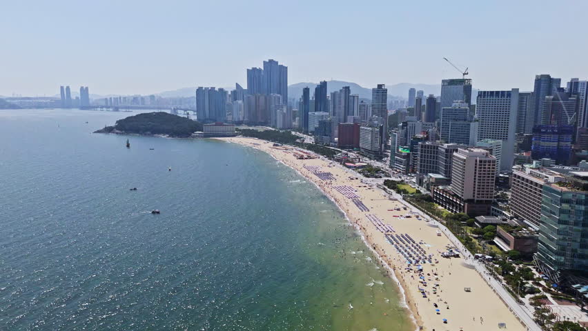 Aerial view backwards in front of the Haeundae beach, in sunny Busan, South Korea
