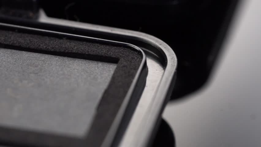 Macro shot of SD memory card showing golden connector pins inside protective case.