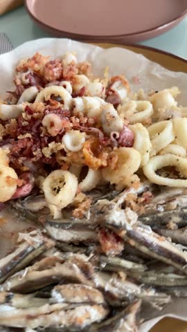 Deep fried anchovies and seafood on plate in kitchen. Healthy eating and organic products.