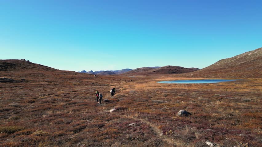 Aerial follows hikers on remote Arctic Circle Trial, Greenland tundra