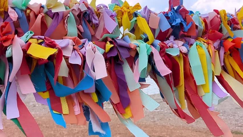 Colorful fabric ribbons fluttering in the wind on a wish tree, symbolizing hope, blessings, and celebration. Ideal for cultural festivals, spiritual concepts, and vibrant decorative backgrounds.