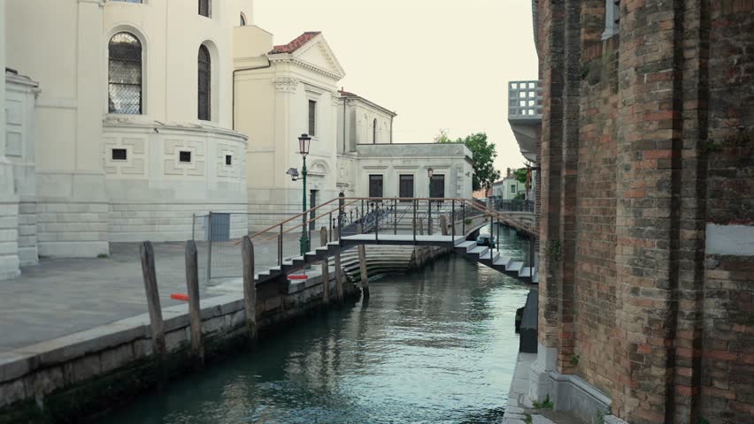 Narrow canal with small bridge and historic buildings