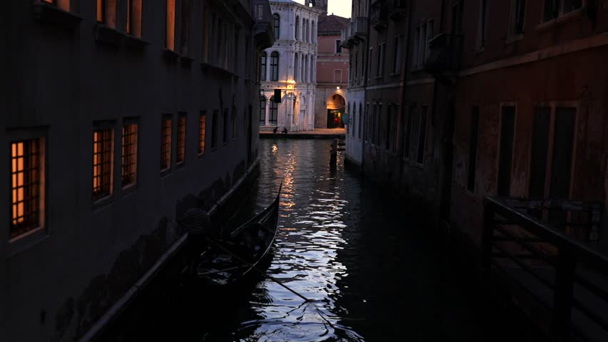 Evening canal view with gondola silhouette Venice Italy