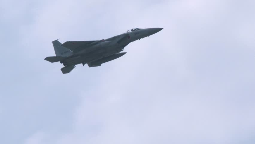 Japan Air Self-Defense Force F-15J fighter jets passing overhead, loaded with live ammunition
