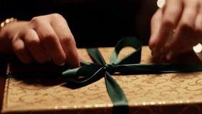 Festive Gift Wrapping Hands Tying Green Ribbon on Ornate Box - Powered by Shutterstock - Get 15% off with code: PIKWIZARD15