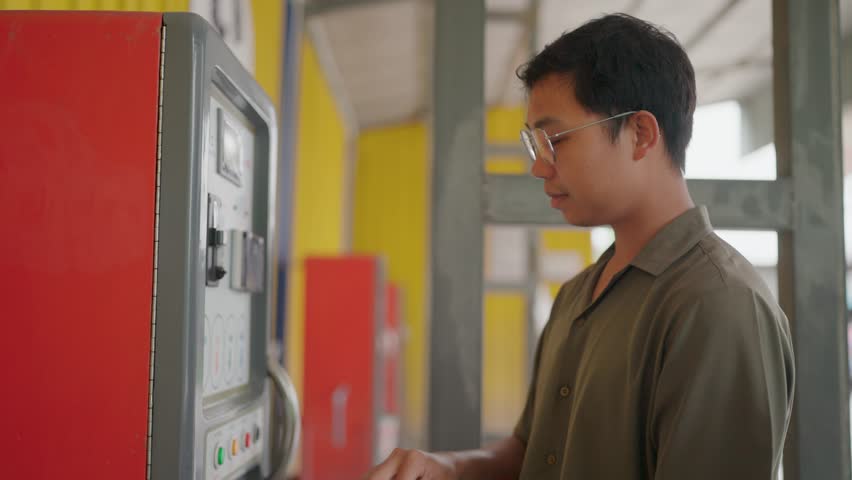 Close up of a man putting money in a vending machine.